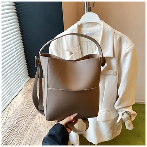 Détail du sac seau en cuir mat avec poignée supérieure et coutures de haute qualité