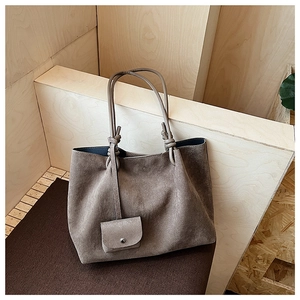 Detail view of dark brown matte tote bag with shoulder strap knot and small pouch