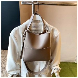 Vue détaillée du sac seau beige montrant la texture en similicuir et la bandoulière réglable