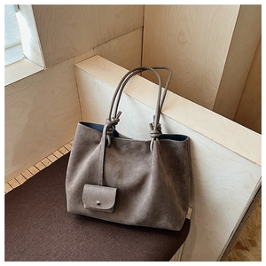 Detail view of large matte tote bag with knotted strap and matching mini coin purse pouch