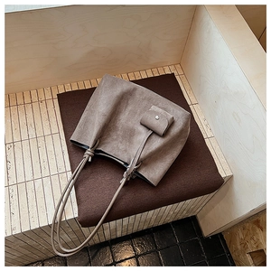 Close-up of matte grey tote bag with small detachable coin purse and fine leather texture