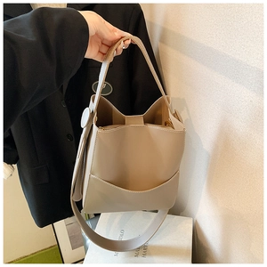 Vue détaillée du sac seau beige avec bandoulière large réglable et poignée femme