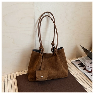 Close-up of deep brown matte suede tote bag with knotted straps and small coin pouch