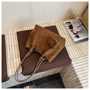 Brown matte tote bag detail with knotted shoulder strap and matching small pouch accessory