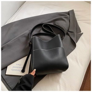 Gros plan détaillé d'un sac seau noir avec des surpiqûres blanches contrastées