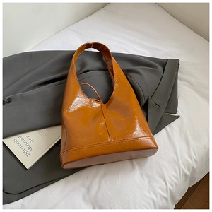 Detail of the vintage brown hobo bag with glossy cracked leather and wide strap