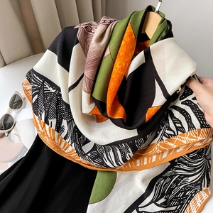 Detail of luxury silk shawl with colorful geometric patterns and abstract leaf textures