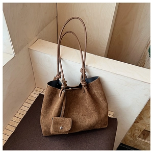 Close-up of brown matte tote bag with shoulder straps and small matching coin purse