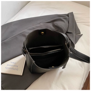 Vue détaillée de l'intérieur du sac seau noir avec compartiment zippé et fermoir aimanté