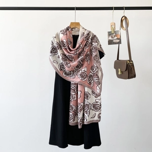 Detail of pink and cream herringbone floral silk scarf draped on a black dress