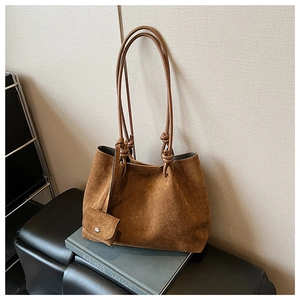 Detailed shot of caramel suede tote bag with matte texture and mini pouch attachment
