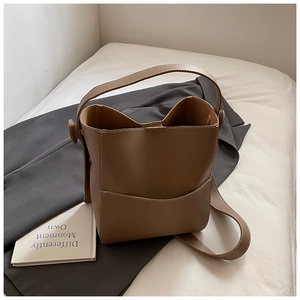 Détail d'un sac seau marron foncé en cuir synthétique avec finitions de couture précises