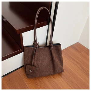 Detail of dark brown suede tote bag with knotted shoulder strap and removable coin purse