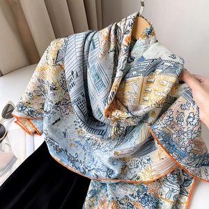 Detail of hand-rolled orange hem on luxurious silk scarf with architectural print