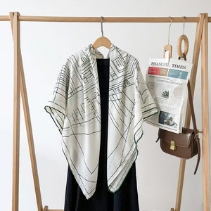 Detailed view of luxury herringbone silk shawl with geometric lines on a wooden hanger