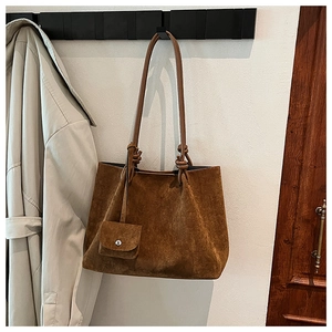 Detailed macro shot of vintage brown matte suede tote bag with matching coin pouch accessory