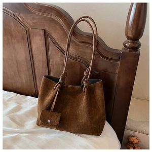 Detailed close-up of dark brown matte suede tote bag with small attached accessory pouch