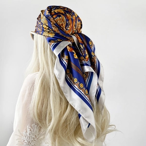 Dettaglio di un foulard in raso di seta con motivi floreali barocchi blu e oro su modella