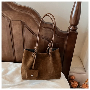 Detailed close-up of dark brown matte leather tote bag with stylish knot strap detail