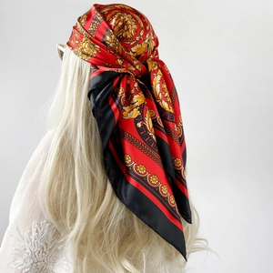 Vista dettagliata di un grande foulard di seta satinata con motivi barocchi oro e rosso