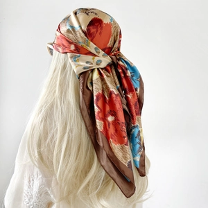 Detail of vintage floral print satin square scarf worn as a stylish headscarf for women