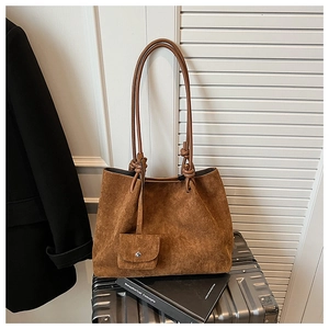 Detailed close-up of dark brown frosted leather tote bag with a small matching pouch