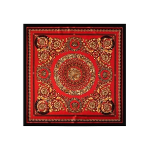 Dettaglio del foulard in raso rosso con motivi barocchi dorati e bordo a greca