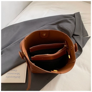 Brown leather bucket bag with internal zipper compartment and magnetic closure