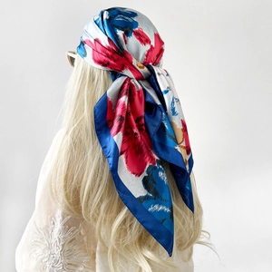 Floral satin square headscarf with vibrant blue and pink patterns on blonde hair