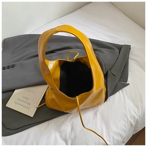 Detailed close-up of a vintage ginger yellow tote bag made of glossy oil wax leather