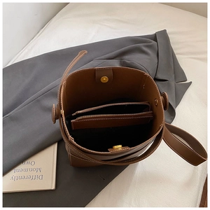 Vue de dessus de l'intérieur d'un sac seau en cuir marron avec pochette zippée et fermoir