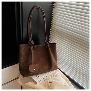 Close-up of brown suede tote bag featuring slim shoulder straps and a matching mini pouch