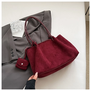 Macro shot of burgundy frosted tote bag featuring intricate knotted straps and mini pouch