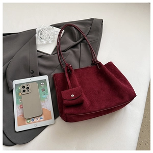 Flat lay of burgundy matte suede tote bag with small coin purse and professional accessories