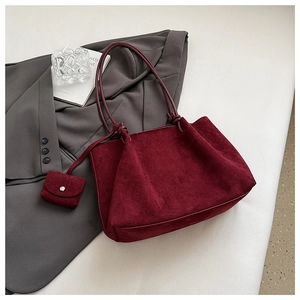 Detail of burgundy matte tote bag with knotted strap and matching mini flap pouch