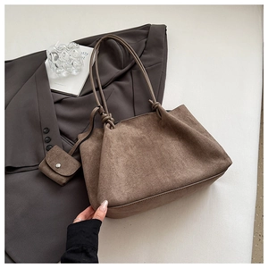 Brown matte suede tote bag detail with knotted handles and a matching small coin purse