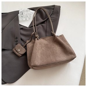Close-up of brown matte suede tote bag featuring twisted knot strap and matching pouch