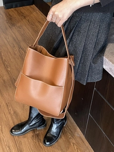 Sac seau en cuir marron foncé avec coutures contrastées blanches au design épuré