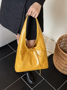 Retro bright yellow patent leather tote bag with bow detail and minimalist Hobo style design