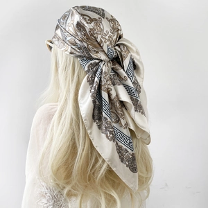 Detail eines im Haar gebundenen Satintuchs mit Barockmuster und Mäandermotiv