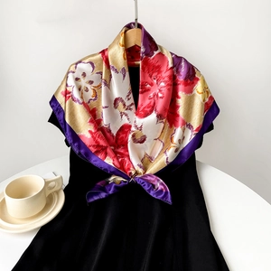 Detailed close-up of a large satin silk scarf with vintage floral patterns on a hanger