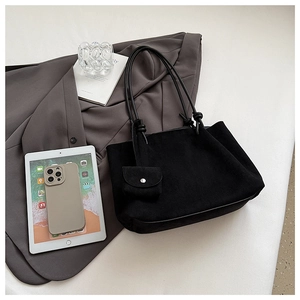 Detailed view of black matte tote bag featuring knotted strap and small clip-on pouch
