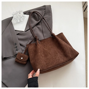 Macro shot of dark brown matte tote bag with shoulder strap knot and small accessory pouch