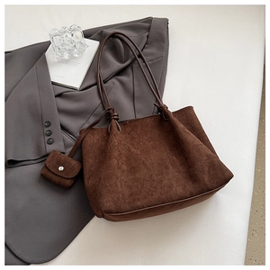 Macro detail of dark brown suede tote bag with matching square coin purse and long straps
