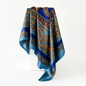 Nahaufnahme eines 90x90cm Satinschals mit blau-goldenen Barockmustern und Glanz