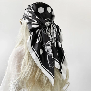 Detail showing the elegant black and white floral polka dot satin headscarf with silk texture