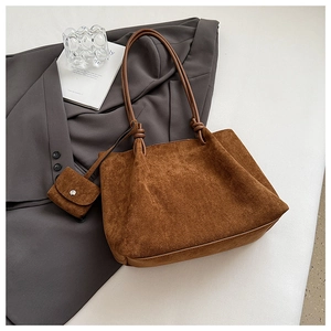 Detail of dark brown matte leather tote bag with handle knot and mini pouch accessory