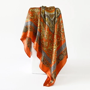 Details des orangefarbenen Satintuchs mit goldenem Barockmuster und Mäander-Bordüre