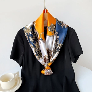 Detail of elegant baroque pattern satin scarf tied over a black top for daily styling