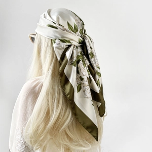Detail of floral satin scarf styled as headwrap with olive green and cream rose patterns